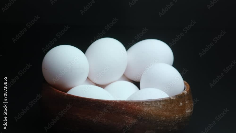 Chicken eggs in a wooden bowl on a background of straw composition Chicken eggs in a wooden bowl on a background of straw composition