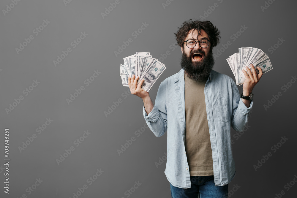 Beaming man with a beard proudly holding up fans of dollar bills, showcasing financial success Beaming man with a beard proudly holding up fans of dollar bills, showcasing financial success