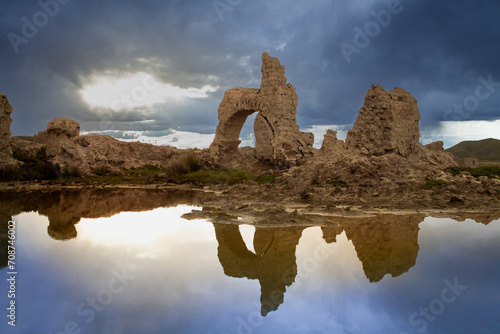 Remains of an adobe house next to a pool of water