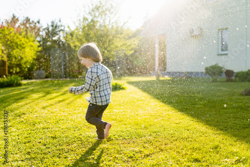 Funny toddler boy having fun outdoors on sunny summer day. Child exploring nature.