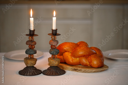 Challah bread, shabbat wine  on the kitchen table. Traditional Jewish Shabbat ritual. Shabbat Shalom.