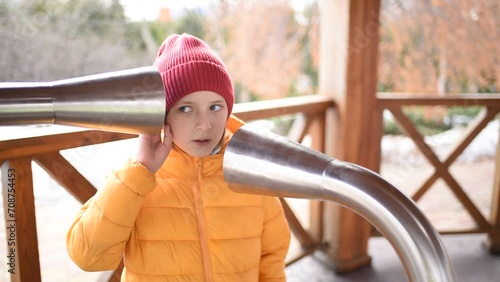  emotional 10 year old child plays on a music platform, speaks and listens to the echo from metal resonant pipes. photo