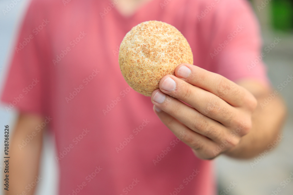 Guy's hand holds mini bread, snack and fast food concept. Selective focus on hands with blurred background Guy's hand holds mini bread, snack and fast food concept. Selective focus on hands with blurred background