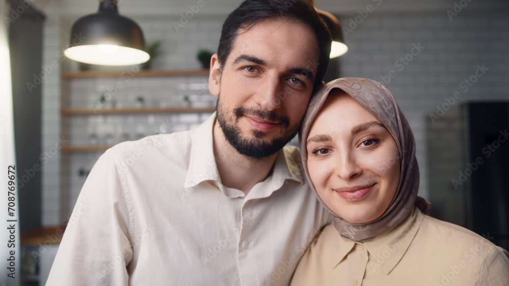 Portrait of young happy married couple hugging each other in the kitchen, smiling and looking at the camera
Portrait of young happy married couple hugging each other in the kitchen, smiling and looking at the camera