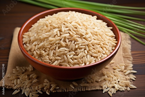 Brown rice in a bowl on a wooden table photo