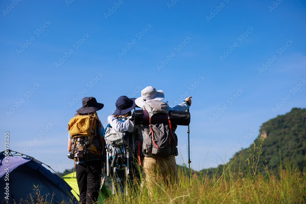 back view family trekking on the hill and blue sky background