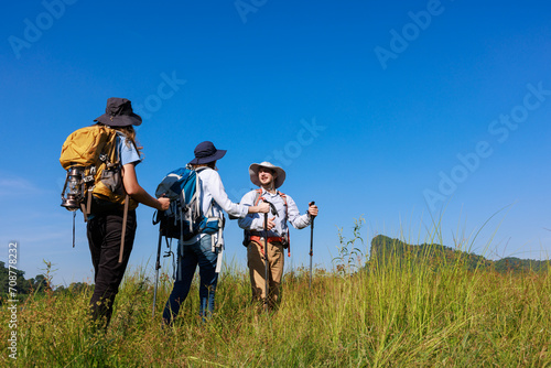 back view family trekking on the hill and blue sky background