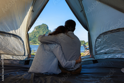 caucasian couple sitting inside a tent on a camping trip,