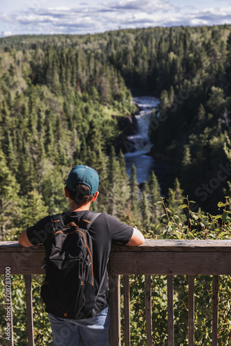 child admiring a lush green landscape with river