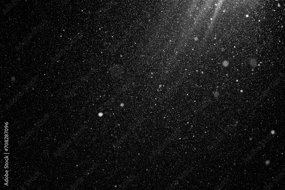 Floating dust particles. White dust  texture on a black background. Snowflakes falling at night from the sky. Great Dust speckle texture background. 