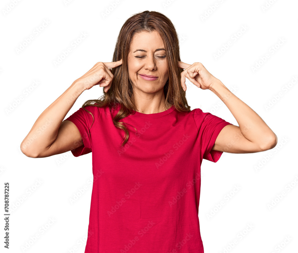 Middle-aged woman portrait in studio setting covering ears with fingers, stressed and desperate by a loudly ambient. Middle-aged woman portrait in studio setting covering ears with fingers, stressed and desperate by a loudly ambient.