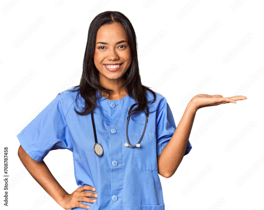 Young Filipina nurse posed in studio showing a copy space on a palm and holding another hand on waist. Young Filipina nurse posed in studio showing a copy space on a palm and holding another hand on waist.