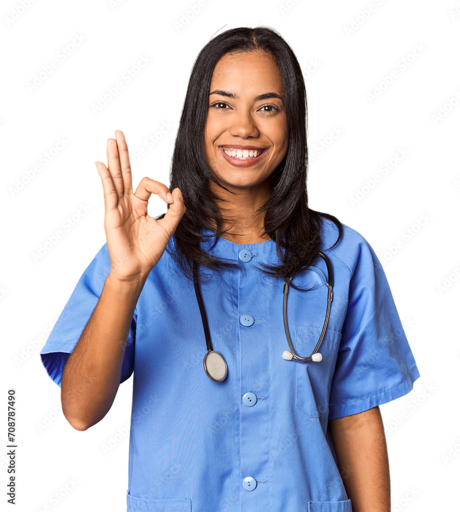 Young Filipina nurse posed in studio cheerful and confident showing ok gesture. Young Filipina nurse posed in studio cheerful and confident showing ok gesture.