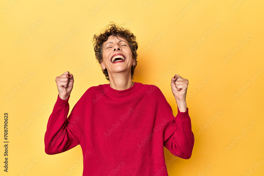 Mid-aged caucasian woman on vibrant yellow celebrating a victory, passion and enthusiasm, happy expression. Mid-aged caucasian woman on vibrant yellow celebrating a victory, passion and enthusiasm, happy expression.