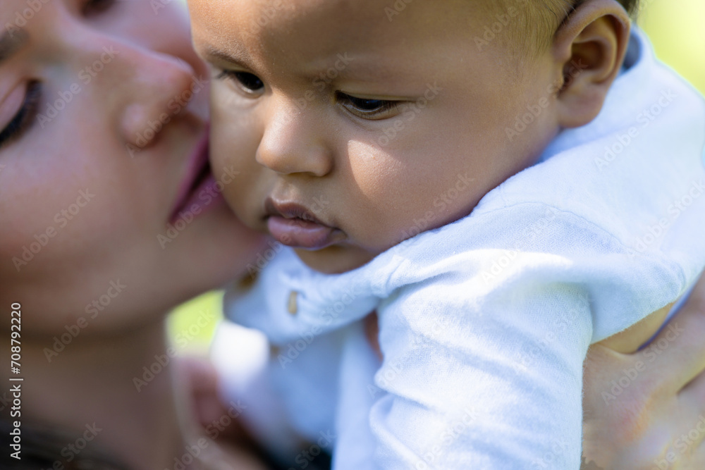 Mothers kiss. Close up portrait of mother kissing multiracial baby. Mother kiss Biracial child