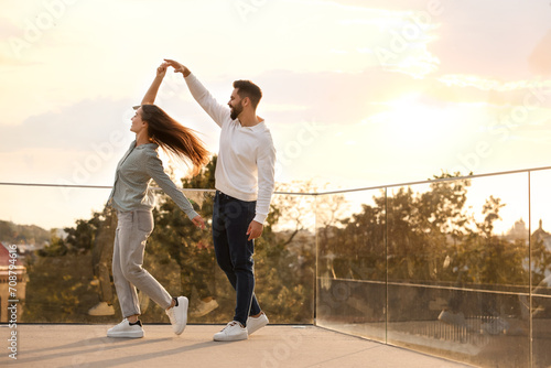 Cuadro en lienzo Lovely couple dancing together outdoors at sunset, space for text