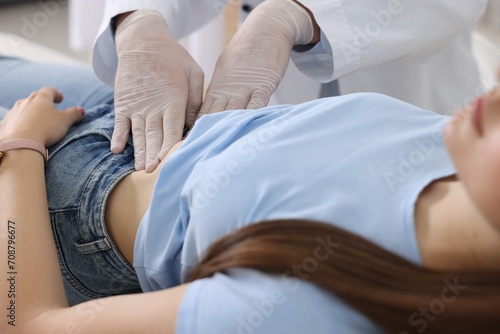 Gastroenterologist examining patient with stomach pain in clinic, closeup photo
