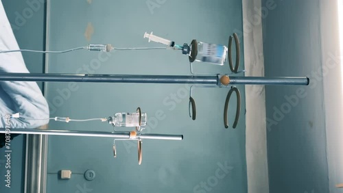 Medical infusion stands with a dropper bottles and a IV with a drip chambers in a observation ward. Intravenous injections, medical care in a clinic or hospital. Recovering patients. Vertical video photo