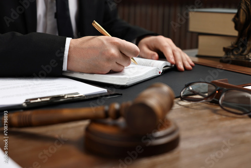 Lawyer taking notes at wooden table, closeup
