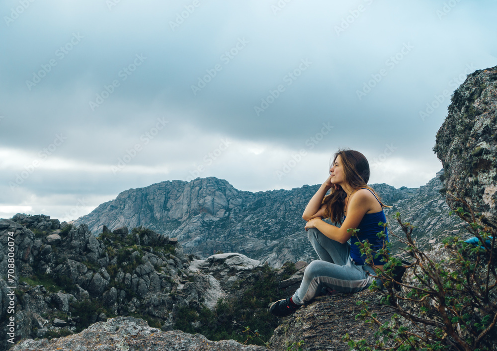 young lady meditate close to the top of a mountain