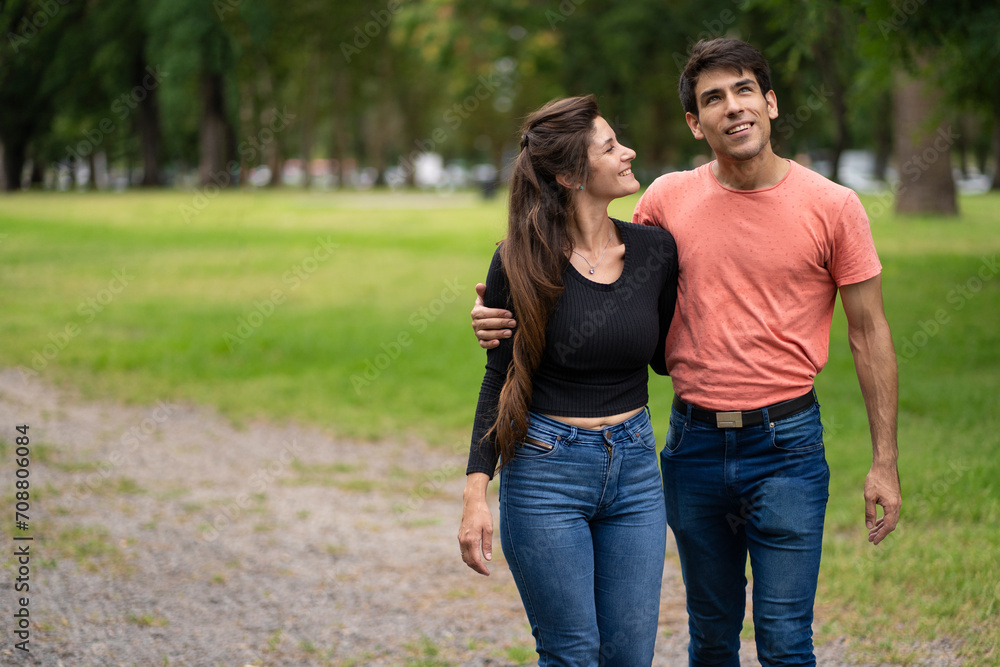 Couple in love walk embraced in the park Couple in love walk embraced in the park