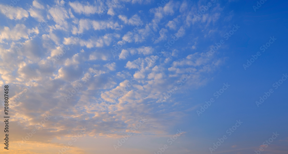 Blue sky background with group of many white fluffy Altocumulus clouds floating on morning sky, beautiful cloudscape widescreen view