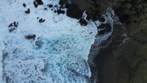 Play of waves on a beach of volcanic rocks at Reunion Island