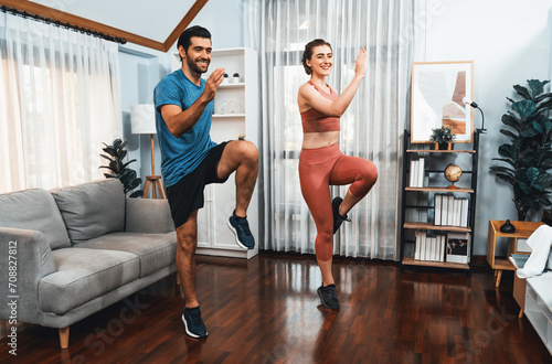 Fototapeta Naklejka Na Ścianę i Meble -  Athletic and sporty fitness couple or exercise buddy running posture at home body workout exercise session for fit physique and healthy sport lifestyle at home. Gaiety home exercise workout training.