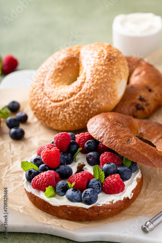 Cinnamon raisin bagel topped with cream cheese and fresh berries