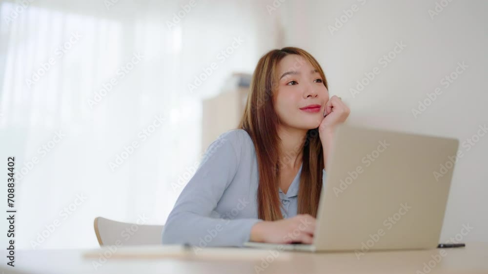 Young asian woman working at home. Happy female using computer laptop on desk at house Young asian woman working at home. Happy female using computer laptop on desk at house