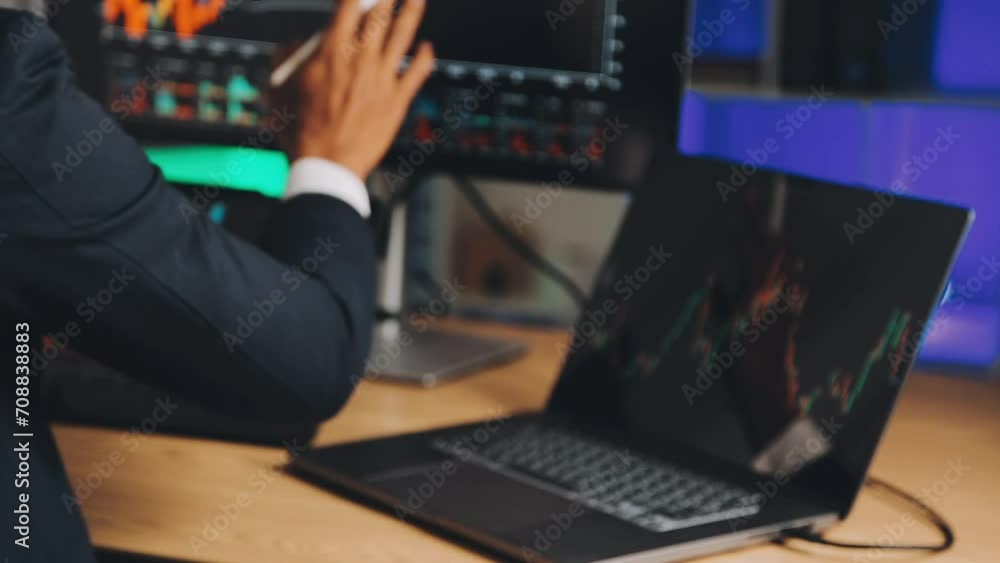 Financial Analyst Working on a Computer with Multi-Monitor Workstation with Real-Time Stocks, Commodities and Foreign Exchange Charts. Businessman Works in Investment Bank City Office at Night. Financial Analyst Working on a Computer with Multi-Monitor Workstation with Real-Time Stocks, Commodities and Foreign Exchange Charts. Businessman Works in Investment Bank City Office at Night.
