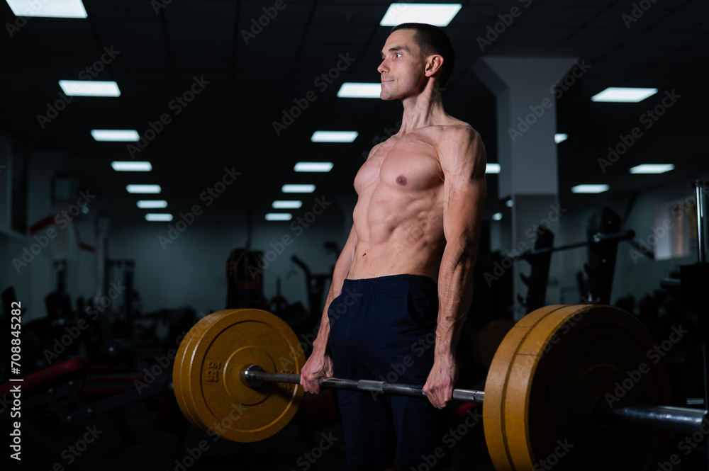 Shirtless man doing bicep exercises with dumbbells in the gym. Shirtless man doing bicep exercises with dumbbells in the gym.