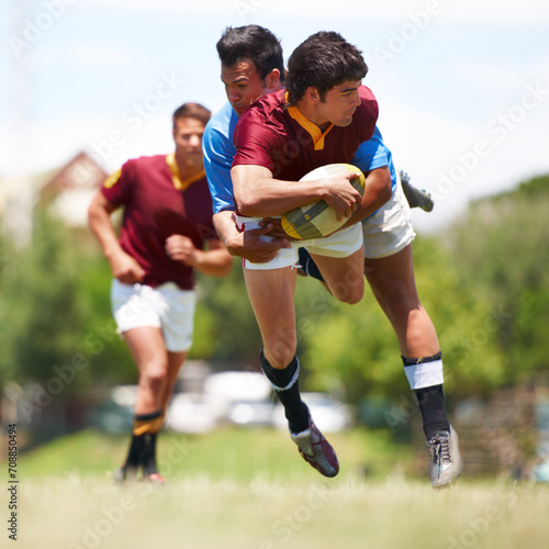 Fitness, tackle and rugby men on a field for sports, ball or action, game or power outdoor. Jump, handball and male team at a park for competitive, training or energy, workout or active challenge