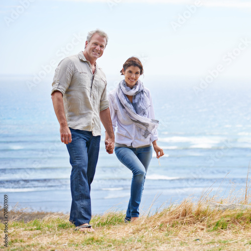 Happy, mature couple and portrait of holding hands at the sea, ocean or walk on the beach in retirement. Summer, vacation or holiday with old man and woman together with love and support in marriage © Katie/peopleimages.com