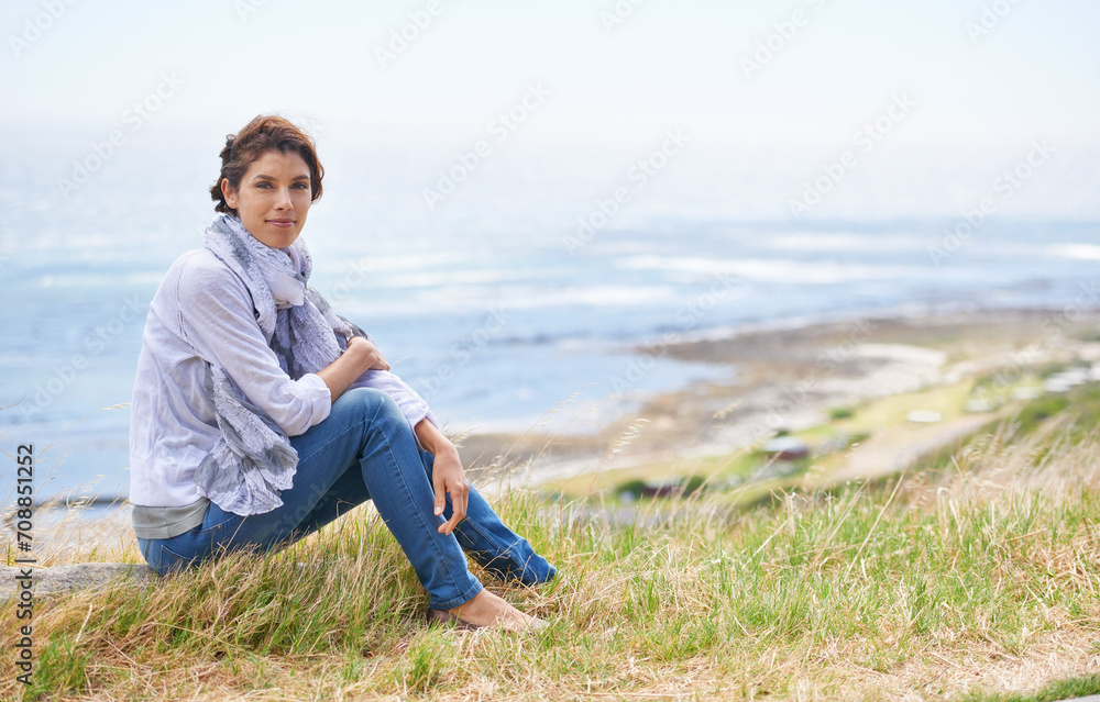 Mature, woman and relax in nature with portrait in landscape with gratitude and peace on holiday or vacation. Retirement, mock up and person on a hill at the beach, ocean or sea with ideas for future