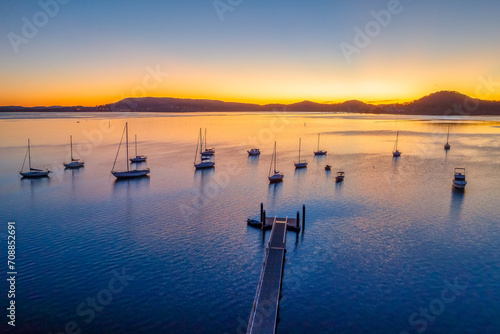 Aerial sunrise over the calm water with boats photo