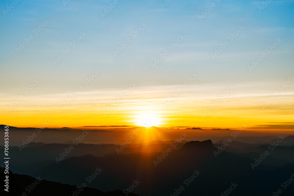 Sunrise horizon over misty mountain layers