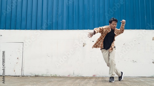 Hispanic funny choreographer dancing in hip hop style. Young happy break dancer perform b-boy dance. Motion shot of funny man practicing street dancing. Outdoor sport 2024. Modern dance. Endeavor.