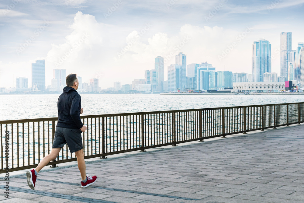 Man in sport clothes enjoying an early morning jog in the city.  Healthy lifestyle.