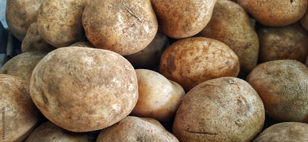 Close up of heap raw potatoes placed on stall of market ready to sold. Potato background Close up of heap raw potatoes placed on stall of market ready to sold. Potato background