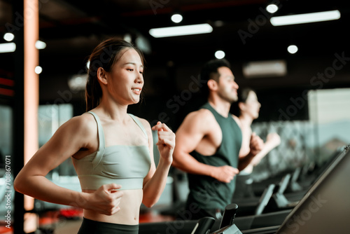 Fit young woman and man running on a treadmill during a workout class at fitness gym © Monster Ztudio