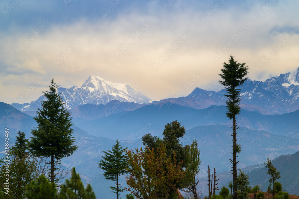 Mountain peak in the mountains. Panoramic view of the snow-covered Himalayan mountain ranges and Nanda Devi peak in the middle of a hill station called Gwaldham in Uttarakhand, India. 