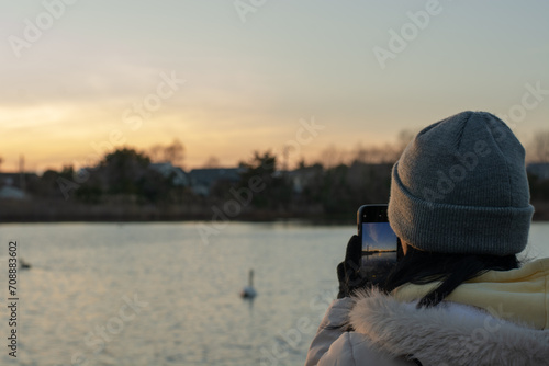 Young woman photographing the sunset