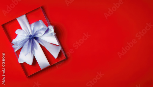 Flatlay of Valentines Day red giftbox with grey ribbon on red background with copyspace