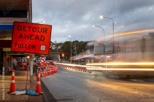 Orange traffic cones on the road. Bus light trails approaching traffic lights. Road works in Auckland. photo