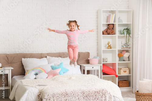 Cute little girl jumping on...