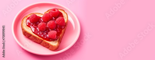 Valentines breakfast.  heart shaped toast with strawberry jam on pink background, horizontal banner, copy space for text, valentines, wedding or birthday card and wallpaper 