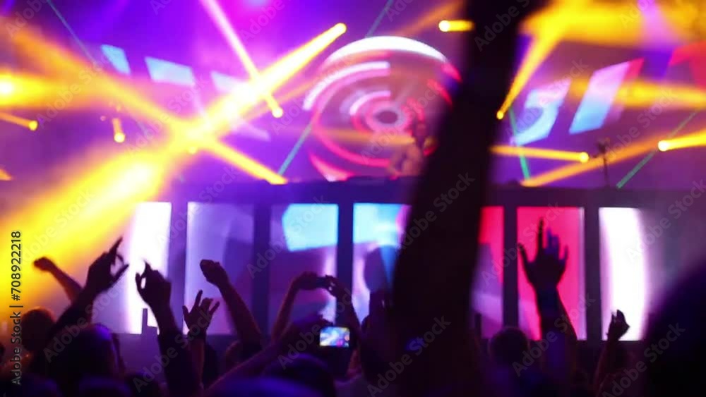 Hands of dancing people with phones and DJ on stage in nightclub Hands of dancing people with phones and DJ on stage in nightclub