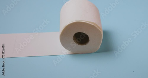 toilet paper roll rolling on blue background photo