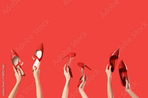 Foto Female hands holding different shoes on red background